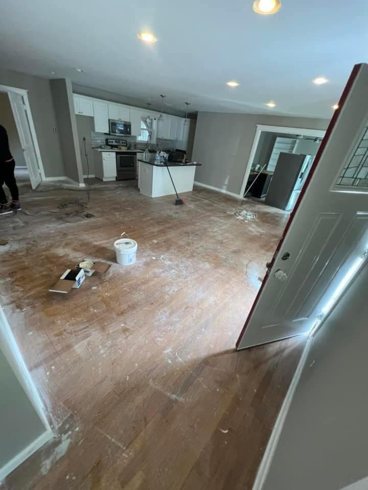 Kitchen and living area before — damaged, dirty hardwood floor